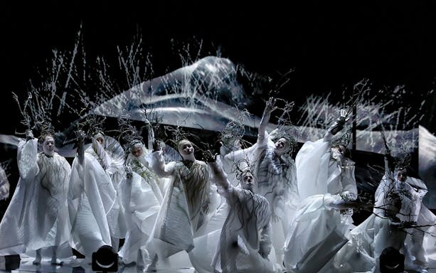 Performers in white costumes with branches during Madama Butterfly on Sydney Harbour.