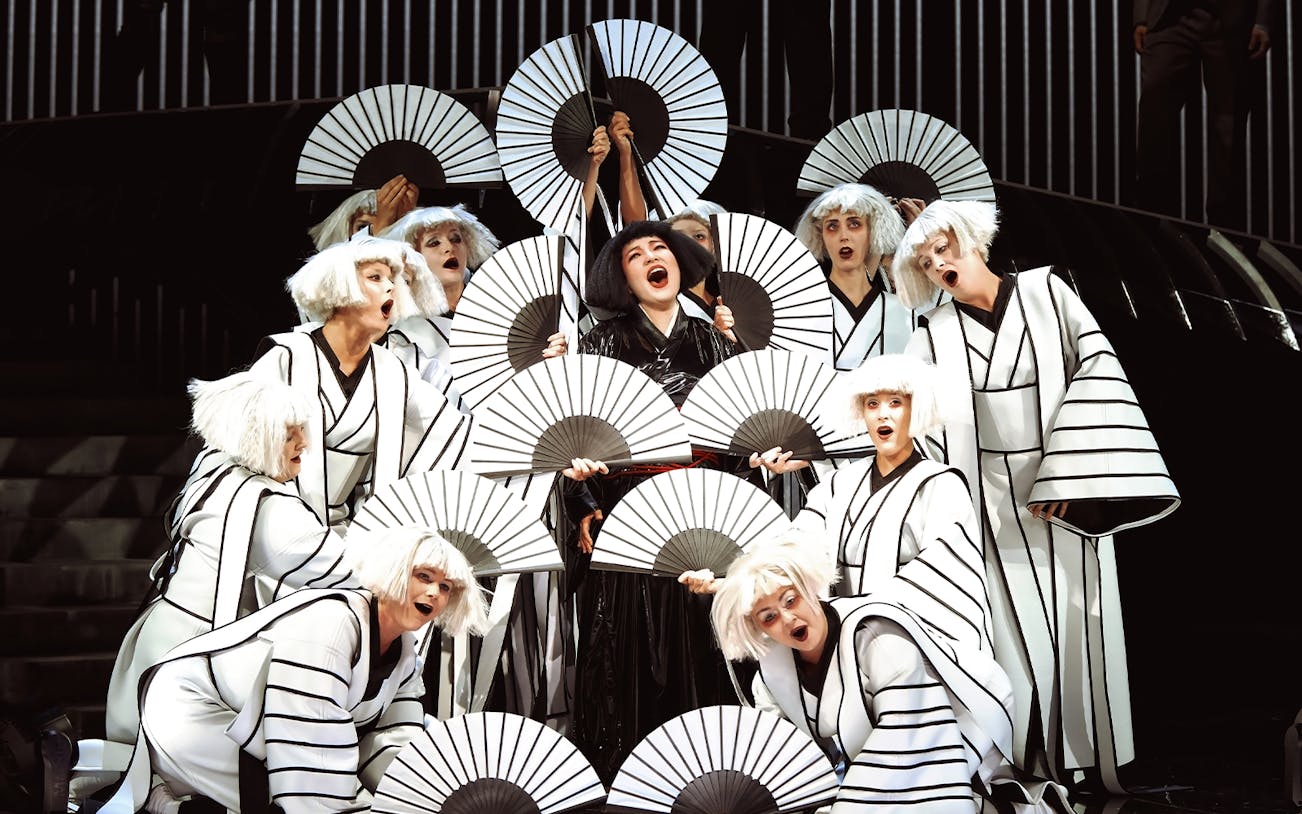Performers in traditional costumes with fans during Madama Butterfly opera.