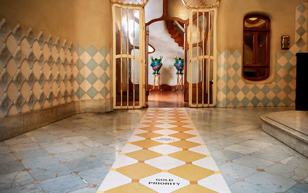 Casa Batlló interior hallway with decorative tiles and open doors in Barcelona.