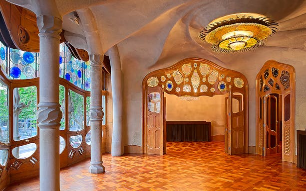 Casa Batlló interior with stained glass windows and ornate ceiling in Barcelona.