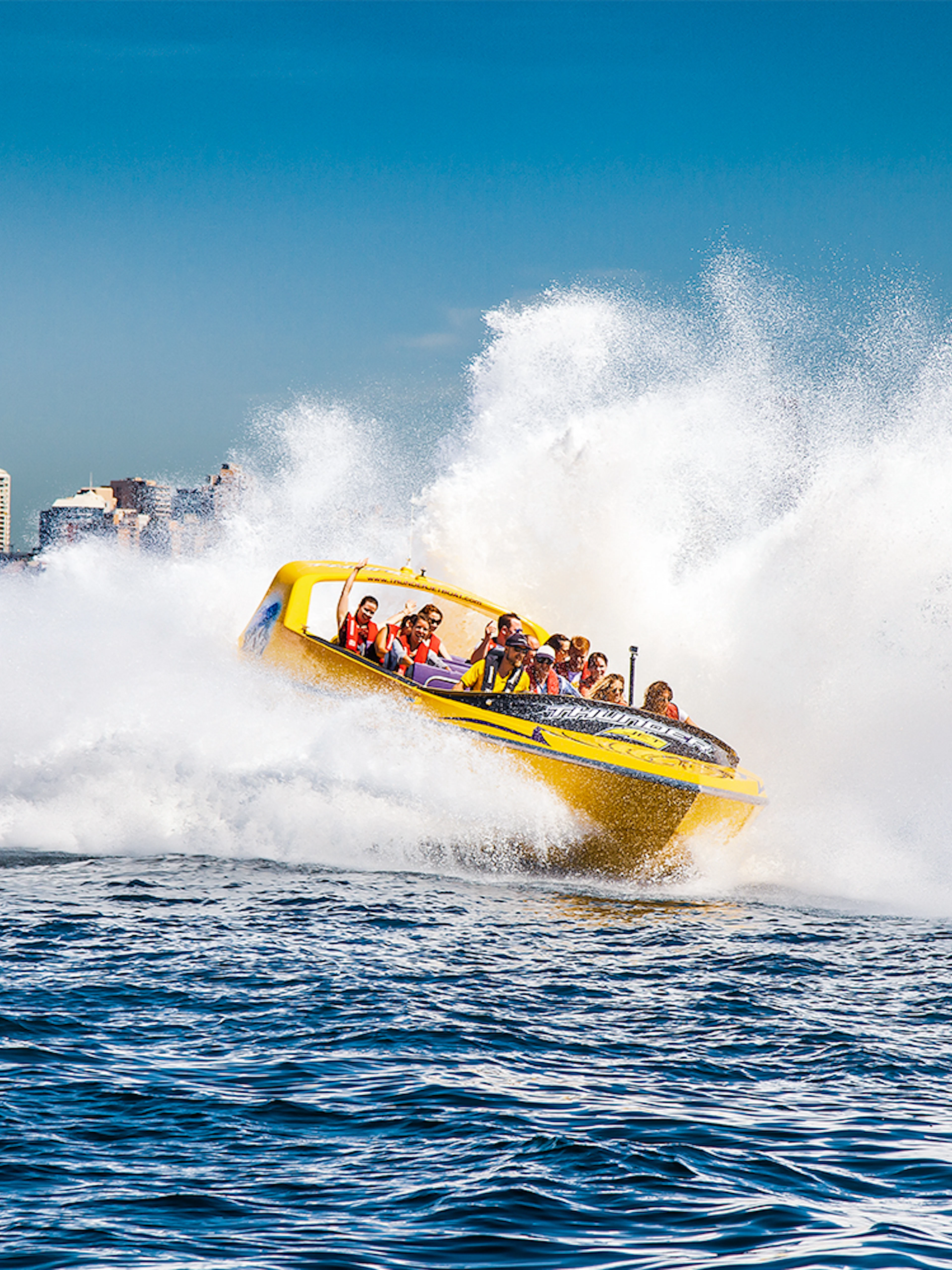 Jet boat speeding through water near Sydney Harbour Bridge, Thunder Thrill Ride.