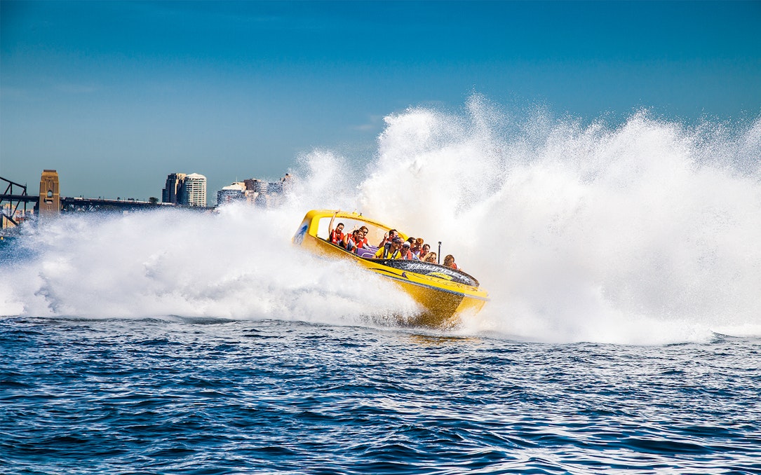 Jet boat speeding through water near Sydney Harbour Bridge, Thunder Thrill Ride.
