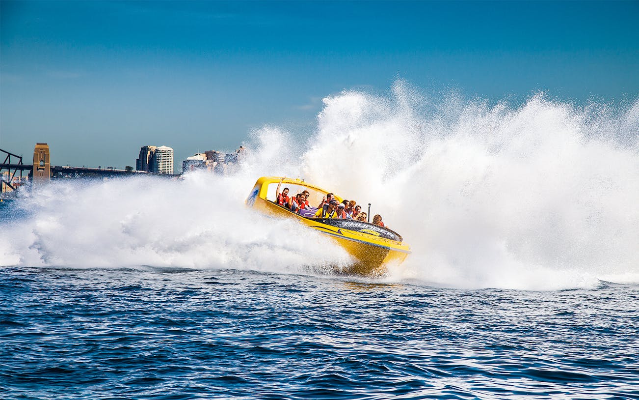 Jet boat speeding through water near Sydney Harbour Bridge, Thunder Thrill Ride.