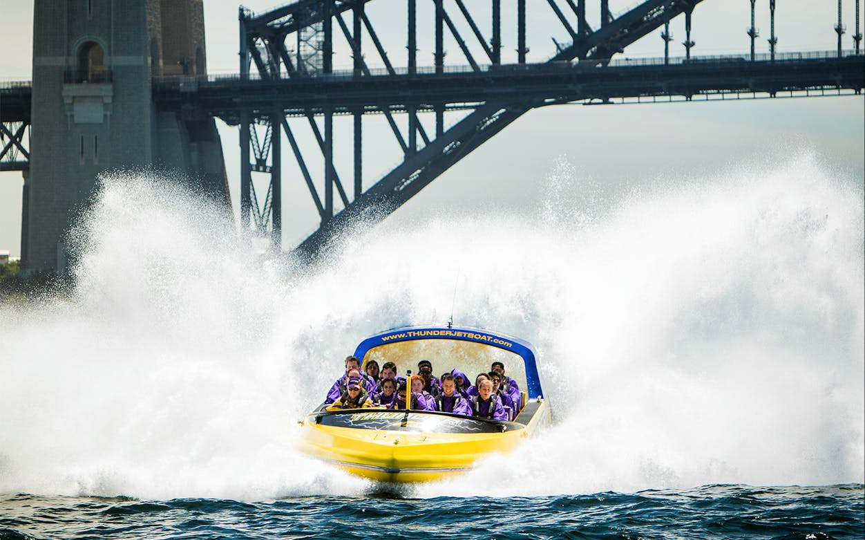 Jet boat speeding on water near Sydney Harbour Bridge, Thunder Jet Extreme Adrenalin Rush tour.