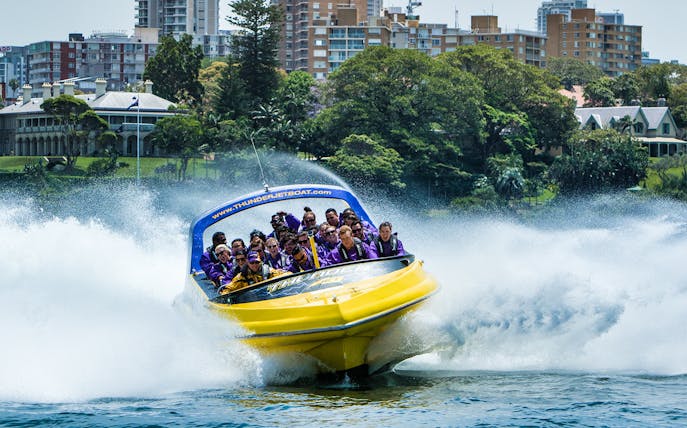 Thunder Jet boat speeding on water with passengers enjoying the ride in Sydney.