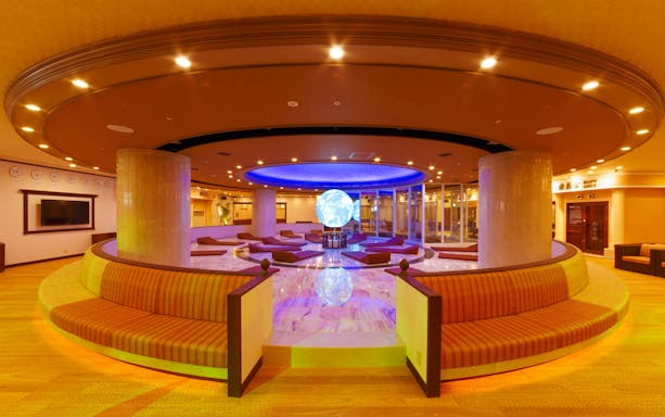 Spa World Osaka seating area with illuminated globe centerpiece.