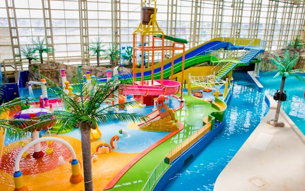 Colorful water park area at Spa World Osaka with slides and play structures.