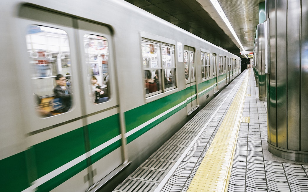Osaka subway train arriving at station platform, part of the Osaka Amazing Pass experience.