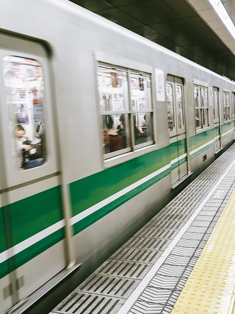 Osaka subway train arriving at station platform, part of the Osaka Amazing Pass experience.