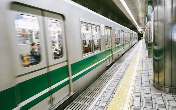 Osaka subway train arriving at station platform, part of the Osaka Amazing Pass experience.