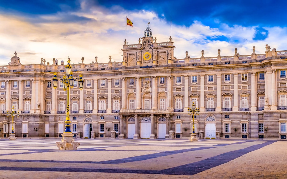 Royal Palace of Madrid facade with Spanish flag, highlighting fast track ticket access.