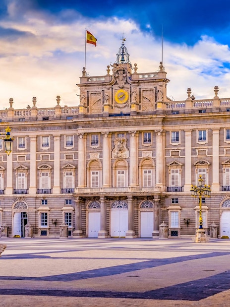 Royal Palace of Madrid facade with Spanish flag, highlighting fast track ticket access.