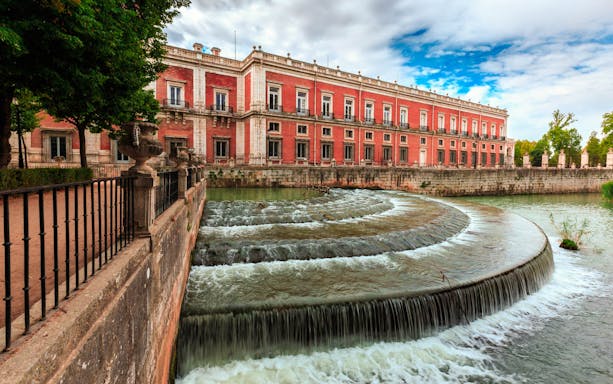 Royal Palace of Aranjuez with cascading water feature in foreground, Spain.