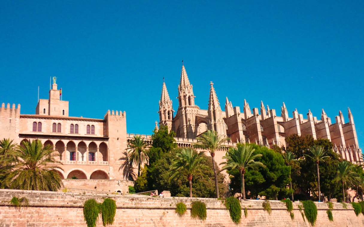 Royal Palace of La Almudaina with palm trees, Mallorca, Spain.