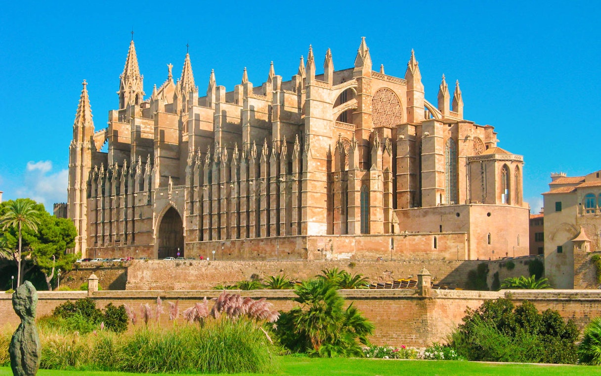 Royal Palace of La Almudaina in Palma, Mallorca, with Gothic architecture and lush gardens.