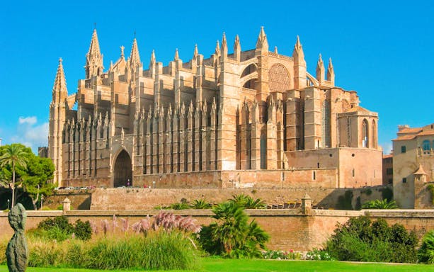 Royal Palace of La Almudaina in Palma, Mallorca, with Gothic architecture and lush gardens.