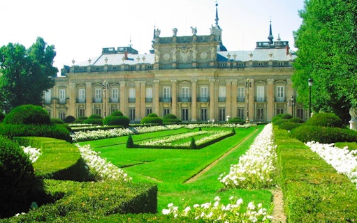 Royal Palace of San Ildefonso with manicured gardens and ornate facade.