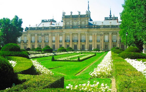 Royal Palace of San Ildefonso with manicured gardens and ornate facade.