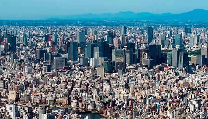 Tokyo Skytree towering over cityscape with clear sky, view from observation deck.