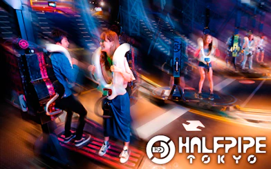 Visitors enjoying a ride at Tokyo JOYPOLIS Halfpipe attraction.