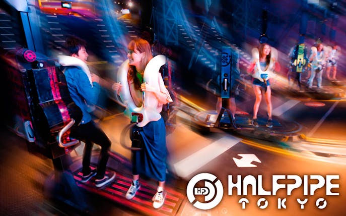 Visitors enjoying a ride at Tokyo JOYPOLIS Halfpipe attraction.