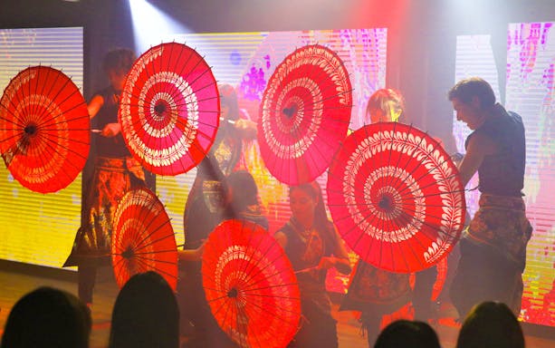 Performers with red parasols at Roppongi KAGUWA Entertainment Show in Tokyo.