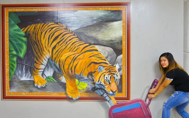 Tiger illusion art at 3D World Dubai Trick-Art ‘Selfie’ Museum with visitor interacting.
