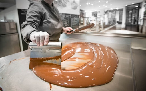 Chocolate being tempered on a metal table during a tasting tour in Venice.