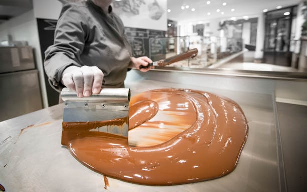 Chocolate being tempered on a metal table during a tasting tour in Venice.