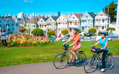 Cyclists ride past the Painted Ladies in San Francisco.