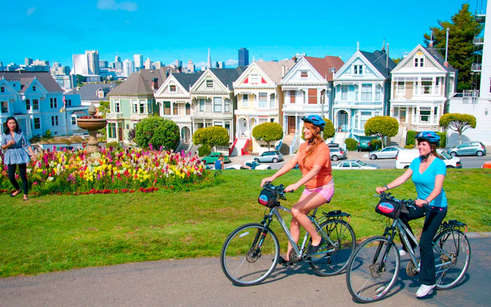 Cyclists ride past the Painted Ladies in San Francisco.