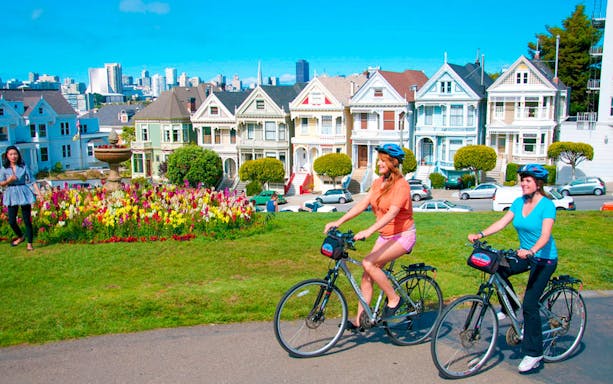 Cyclists ride past the Painted Ladies in San Francisco.