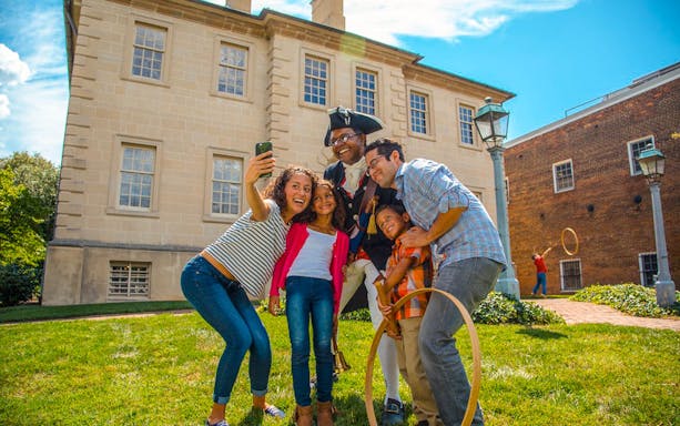Family taking a selfie with a historical reenactor in Washington DC.