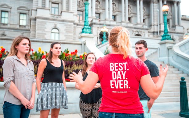 Tour guide leading a group in front of a historic building in Washington DC.