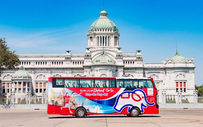 Red double-decker bus in front of Ananta Samakhom Throne Hall, Bangkok, for Elephant GOGO tour.