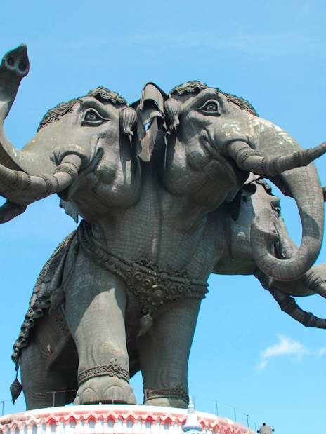 Three-headed elephant statue at Erawan Museum, Bangkok, under a clear sky.