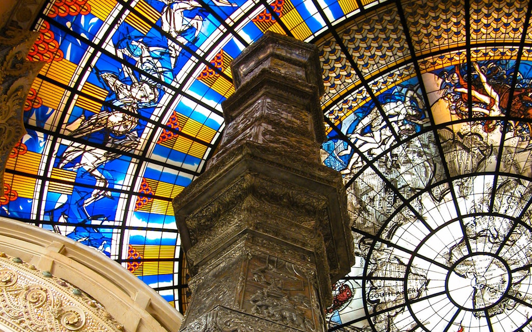 Stained glass ceiling and ornate pillar inside Erawan Museum, Bangkok.