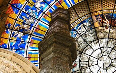 Stained glass ceiling and ornate pillar inside Erawan Museum, Bangkok.