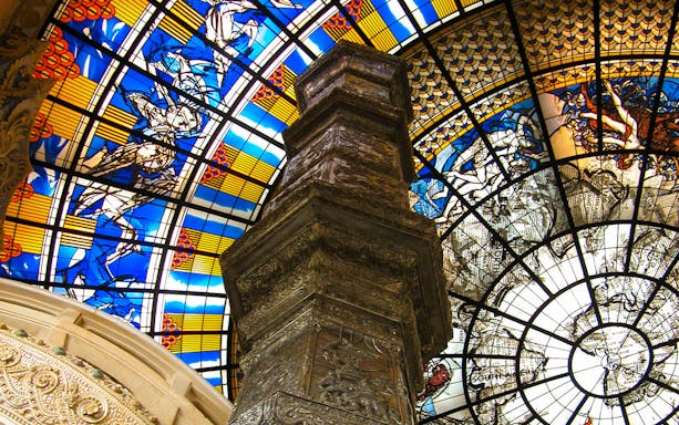 Stained glass ceiling and ornate pillar inside Erawan Museum, Bangkok.