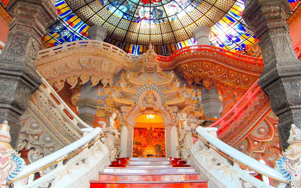 Erawan Museum interior with ornate staircase and stained glass ceiling, Bangkok, Thailand.
