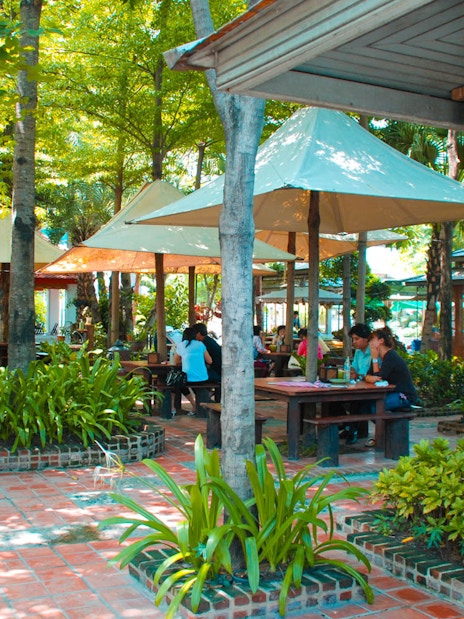 Outdoor seating area at Erawan Museum with visitors under shaded canopies.