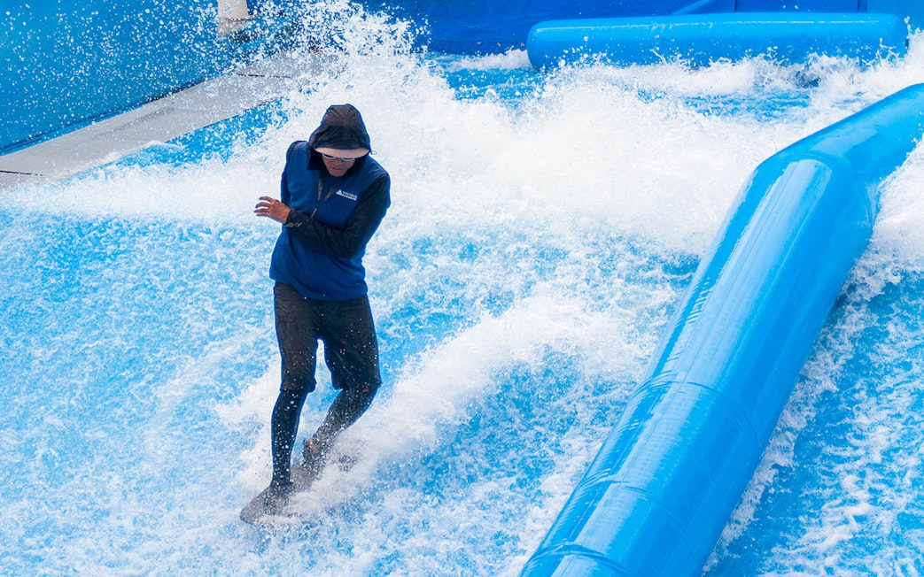Surfer balancing on artificial wave at Flow House Bangkok.