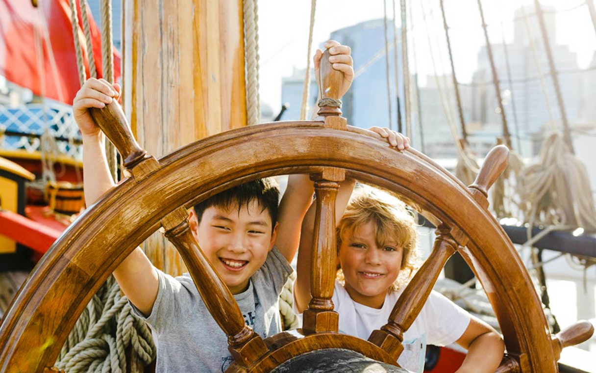 Children steering a ship's wheel at the Australian National Maritime Museum, Sydney.