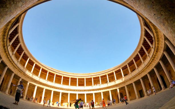 Alhambra's circular courtyard with tourists, part of Granada hop-on hop-off tour.