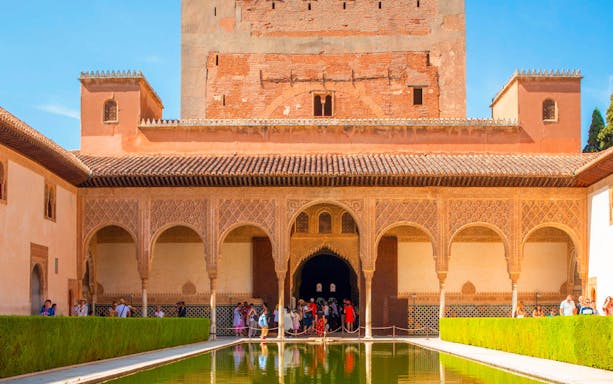 Alhambra's intricate arches and reflecting pool in Granada, Spain.