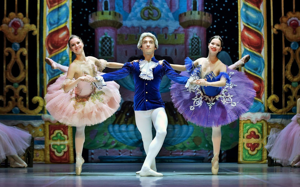 Ballet dancers performing on stage with colorful costumes and a castle backdrop, Stars of Russian Ballet.