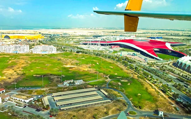 Aerial view of Ferrari World and surrounding landscape during a seaplane tour in Abu Dhabi.