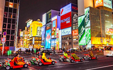 Go-karts driving through illuminated streets of Osaka during Akiba Kart experience.