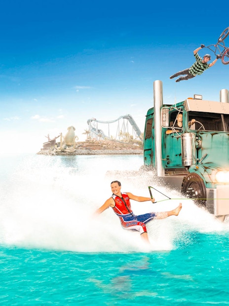 Jet ski and wakeboard stunts at Gold Coast Sea World with roller coaster in background.