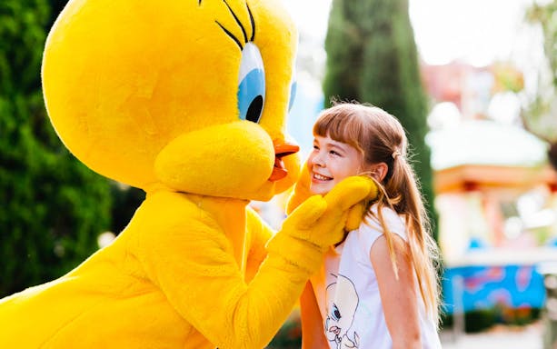 Child smiling with Tweety character at Warner Bros Movie World.